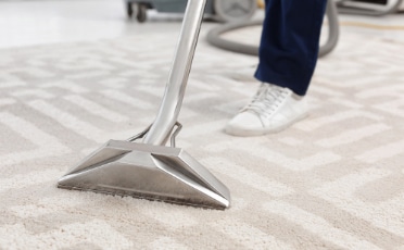 Man Using a Vacuum Cleaner to Clean a Carpet — Upholstery & Carpet Cleaning on the Sunshine Coast, QLD