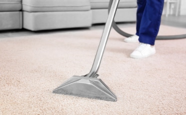 Person Vacuuming Carpet with A Vacuum Cleaner — Upholstery & Carpet Cleaning on the Sunshine Coast, QLD