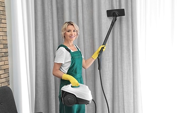 Woman Cleaning Grey Curtain — Upholstery & Carpet Cleaning on the Sunshine Coast, QLD