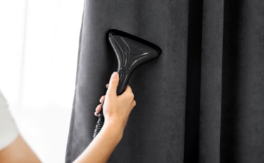 Person Cleaning Black Curtain — Upholstery & Carpet Cleaning on the Sunshine Coast, QLD