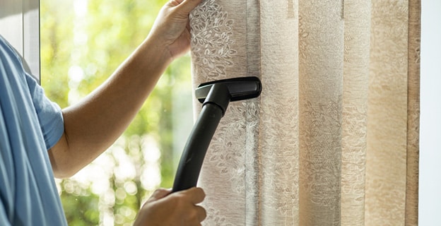 Man Dry Cleaning Curtain with Vacuum Cleaner — Upholstery & Carpet Cleaning on the Noosa, QLD