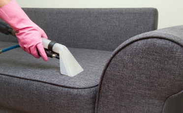 Person with Pink Gloves Cleaning Couch — Upholstery & Carpet Cleaning on the Sunshine Coast, QLD