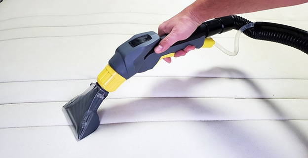 Man's Hand Cleans a Modern White Mattress — Upholstery & Carpet Cleaning on the Noosa, QLD