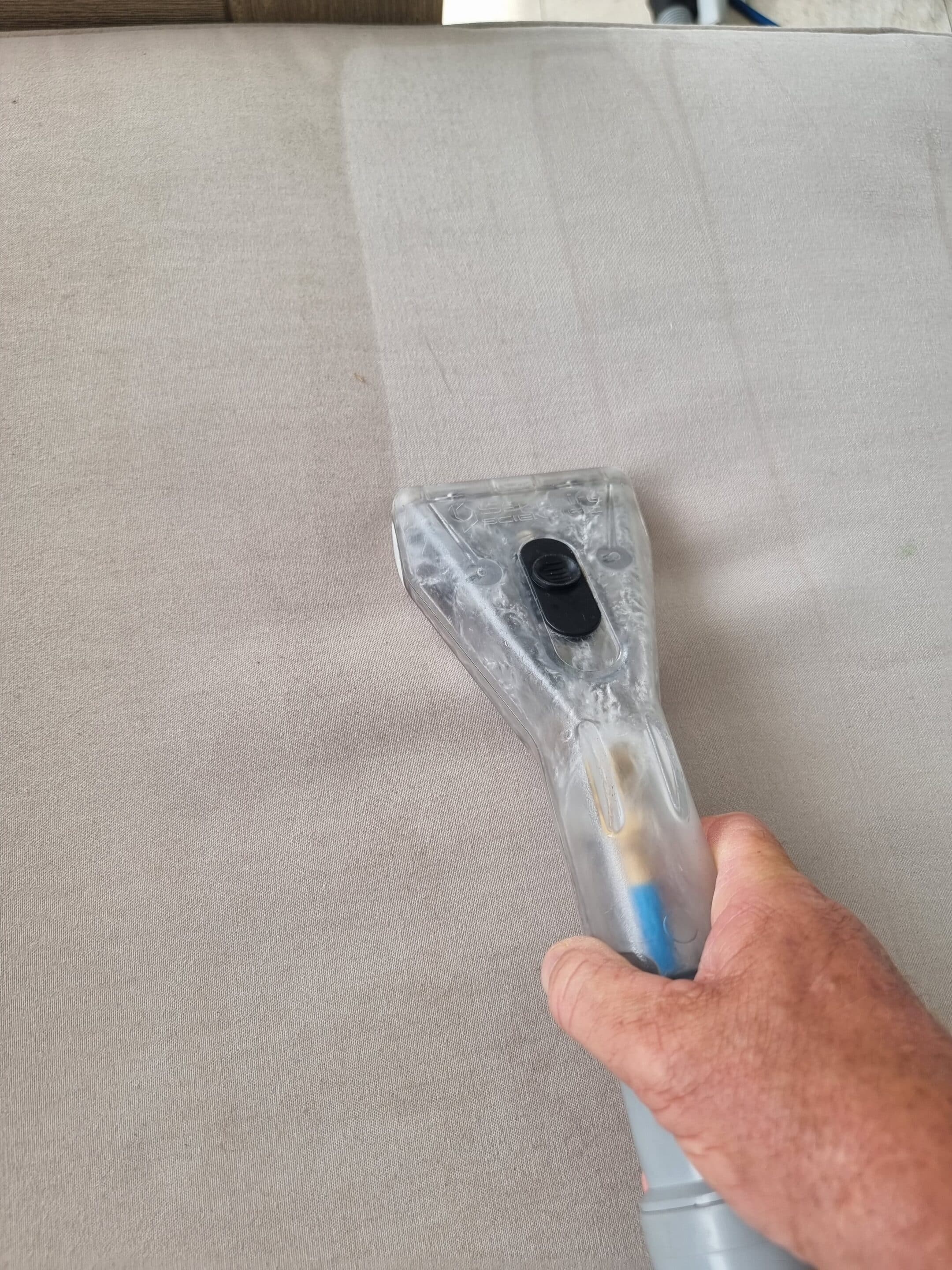 Close-up Photo Of A Person Cleaning A Couch Using a Vacuum — Carpetmaster in Bli Bli, QLD